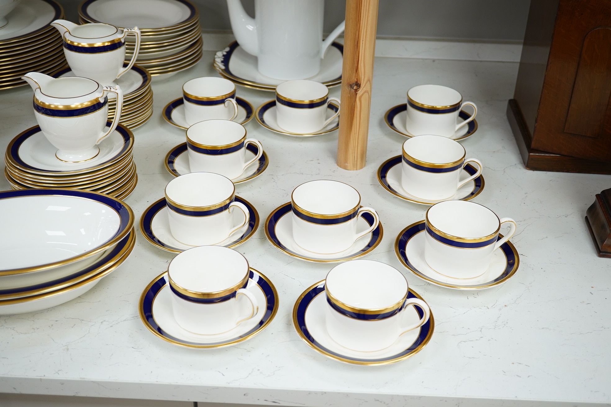 A large part Coalport ‘Rutland’, gilt and blue banded dinner and coffee service, coffee pot and cover 24cm high. Condition - the dinner service is for twelve place settings, the coffee set ten place settings. Condition -